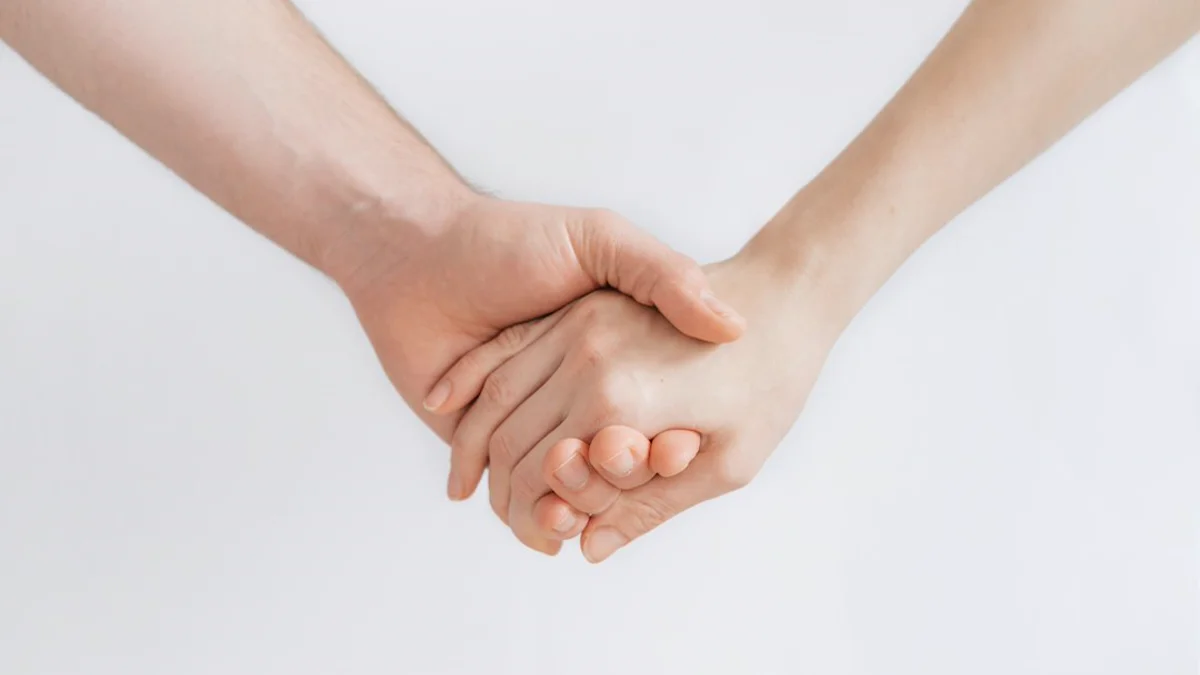Hình ảnh đôi bàn tay nâng niu ấm áp tượng trưng cho sự vỗ về và thấu hiểu vết thương lòng
